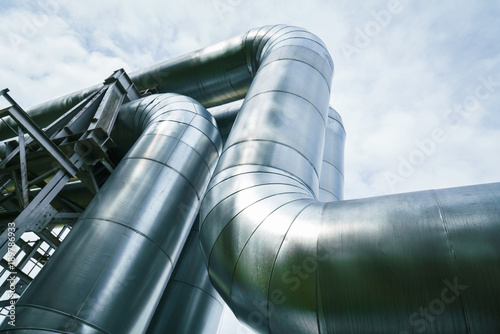 Industrial pipelines on pipe-bridge against blue sky