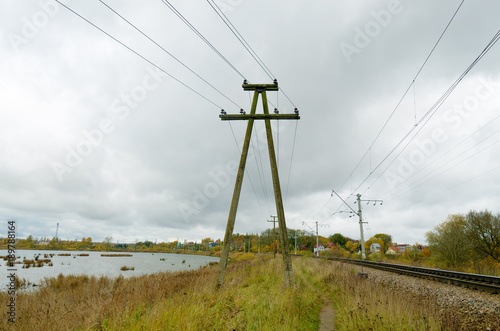 The poles with the electric current along the railway.