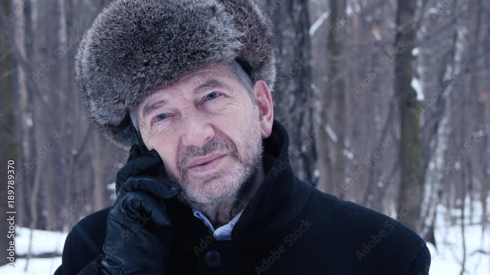 Elderly Man Talking On Mobile Phone On A Winter Day In The Forest Elderly Man Talking On Mobile Phone On A Winter Day In The Forest