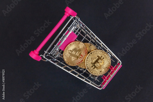 Stack of coins bitcoin in mini shopping cart toy, concept of mining. Electronic virtual money for web banking and international network payment. Symbol of crypto currency photo