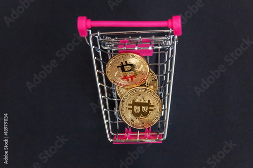 Stack of coins bitcoin in mini shopping cart toy, concept of mining. Electronic virtual money for web banking and international network payment. Symbol of crypto currency photo