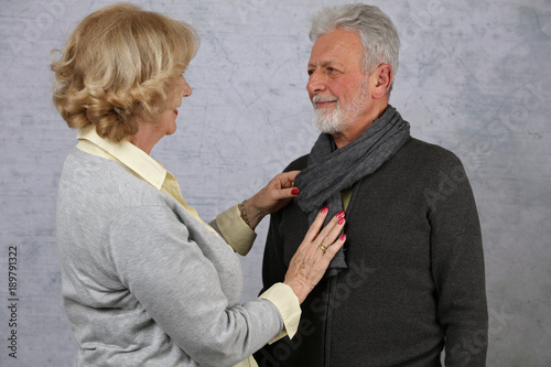 Happy elderly ncouple in love. Modern casual dressed olderman and woman, lifestyle concept. Senior woman helping her husband with outfit. photo