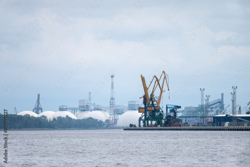 View on the port taps in the river port of Daugava, in Riga. The chemical substances transfer terminal can be seen in the background