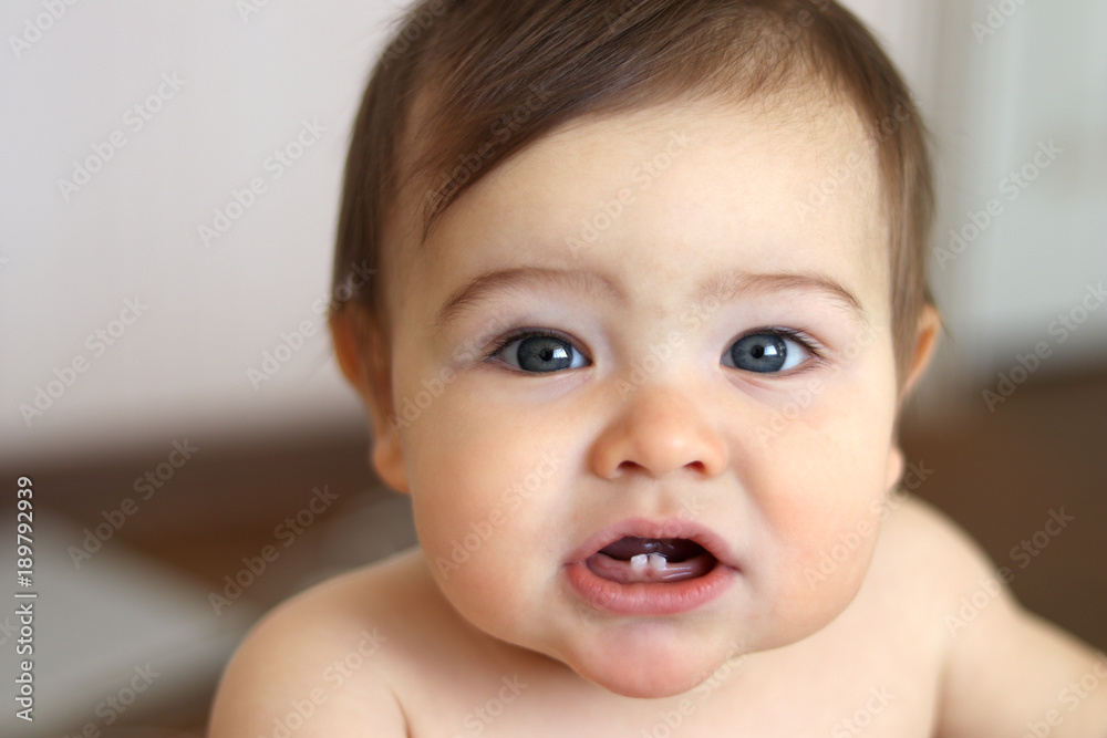 Cute little baby boy showing his first teeth, close-up Cute little baby boy showing his first teeth, close-up