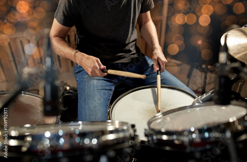 musician playing drum kit at concert over lights photo