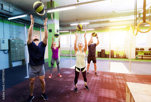 group of people with medicine ball training in gym