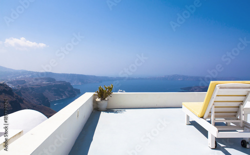Two sunbeds on the terrace with sea view. Relax on Santorini island, Greece.