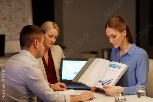 business team with papers working late at office