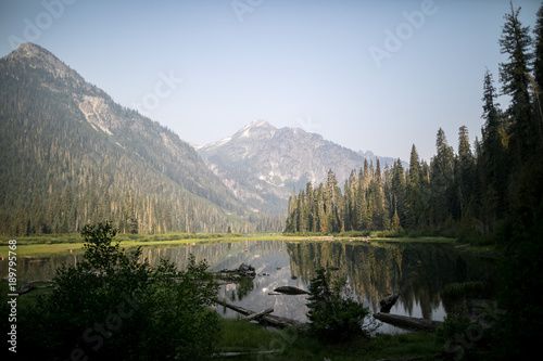 mountain lake with peaks and trees reflecting