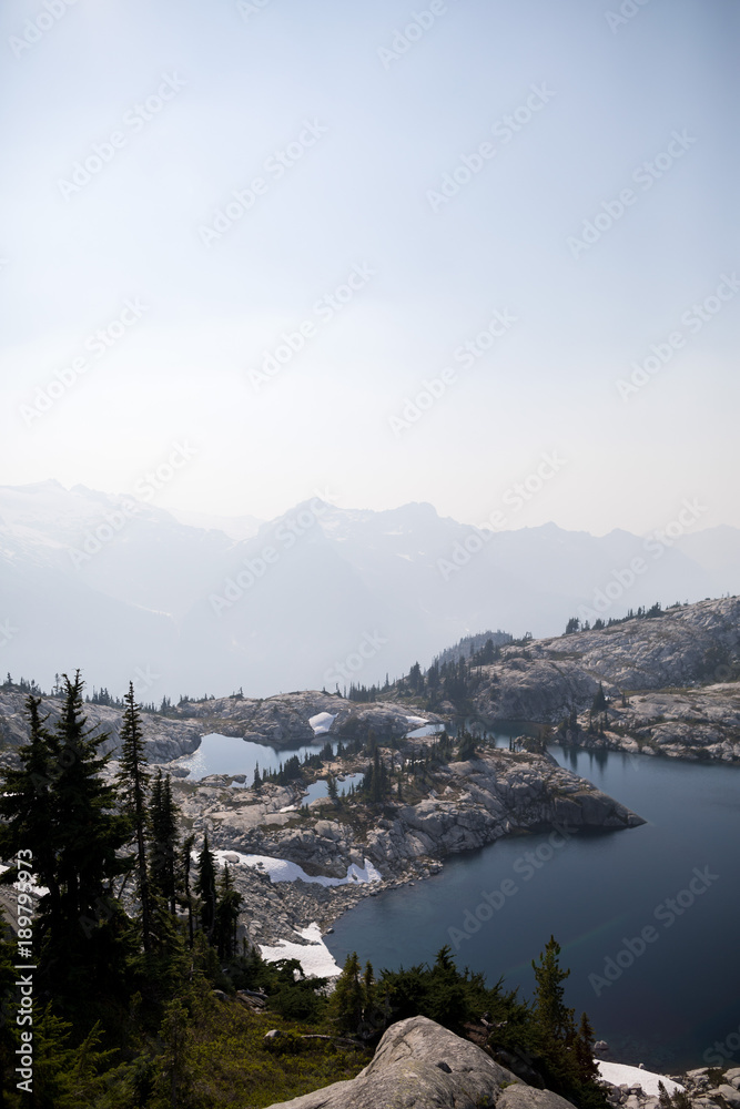 mountain lake with trees and a haze