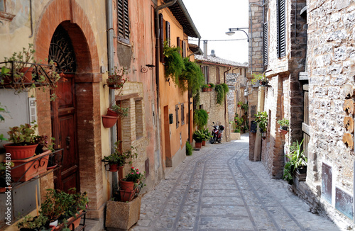 Fototapeta Naklejka Na Ścianę i Meble -  Traditional italian medieval alley in the historic center of beautiful little town of Spello , in Umbria region - central Italy