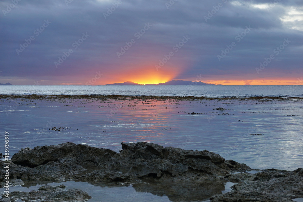 Sunset light on Tahaa island and Bora Bora on the right at the horizon, natural scene, seen from Huahine island, south Pacific ocean, French Polynesia Sunset light on Tahaa island and Bora Bora on the right at the horizon, natural scene, seen from Huahine island, south Pacific ocean, French Polynesia