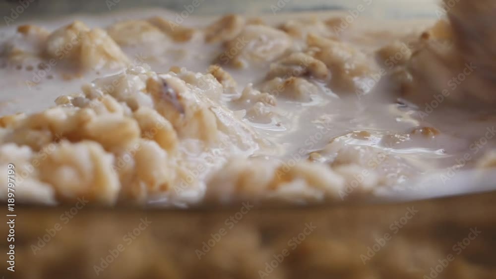 Adding a milk into oatmeal closeup shot Adding a milk into oatmeal closeup shot