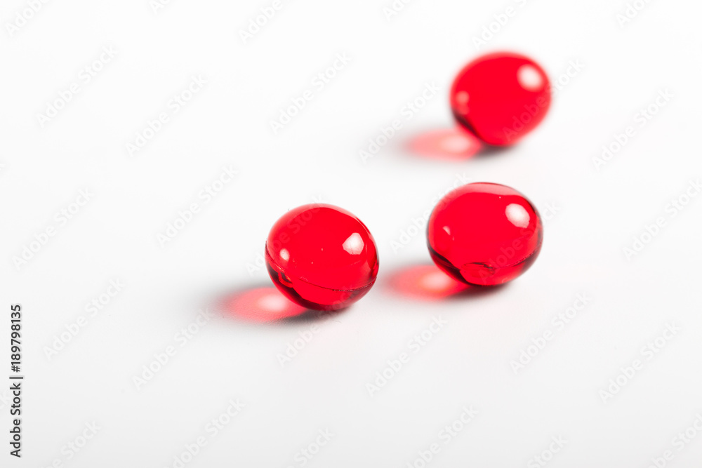 red capsules closeup on a white background. Medical background. Macro. tablets red capsules closeup on a white background. Medical background. Macro. tablets