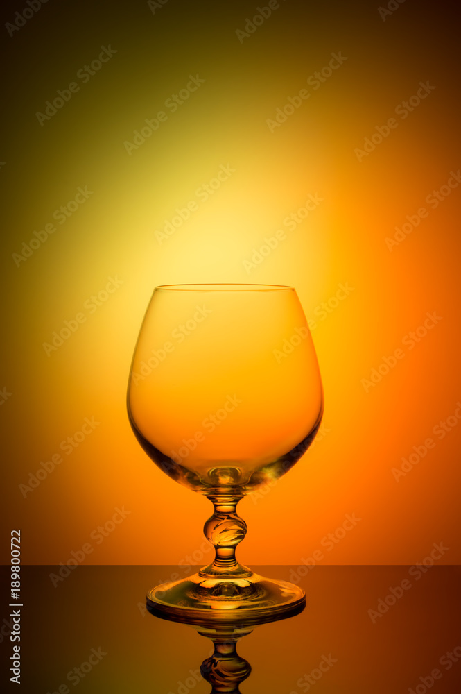 Wineglass on a color background with a black vignette. A tall Wineglass with a thin stalk Wineglass on a color background with a black vignette. A tall Wineglass with a thin stalk