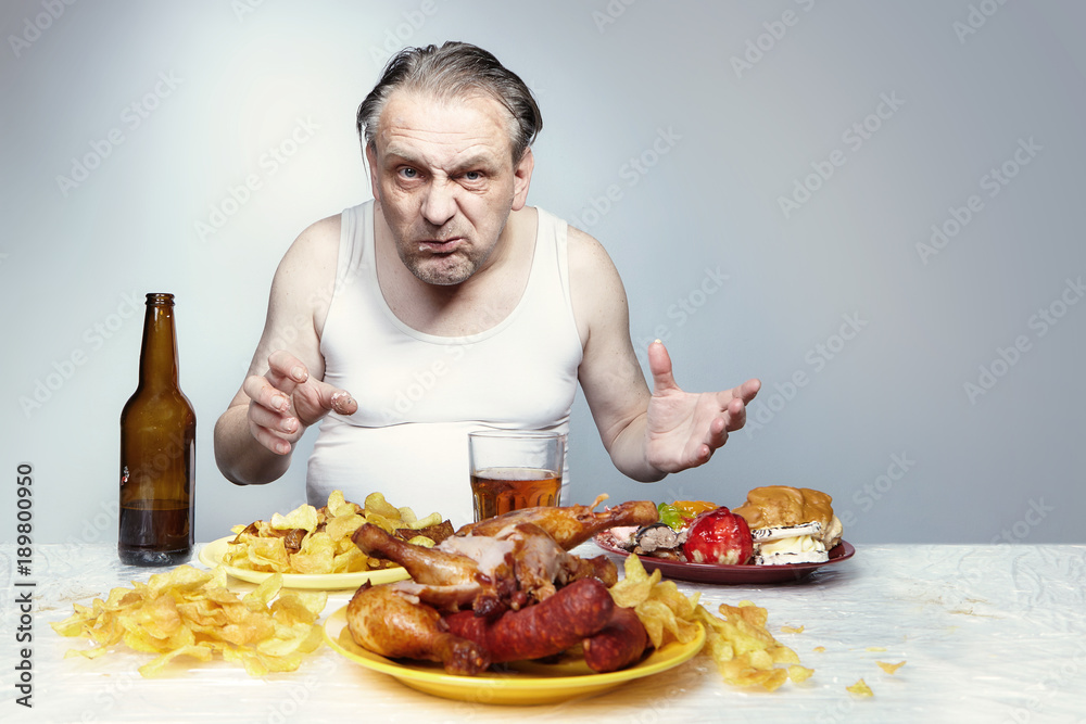 Aging man in a-shirt enjoying unhealthy meal.