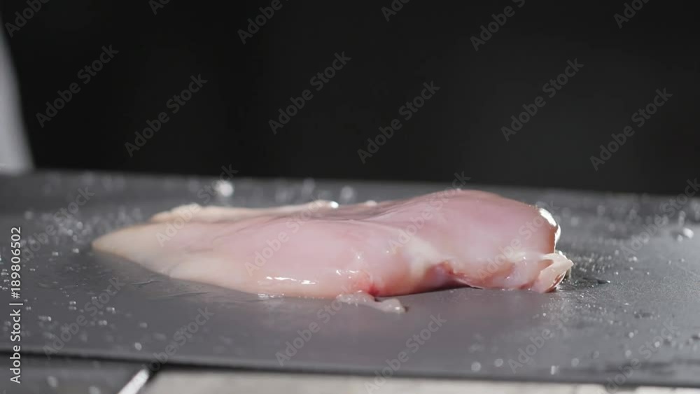Raw chicken ready for marinade with lemon. Cooking with fire in frying pan. Professional chef in a kitchen of restaurant cooking. Raw chicken ready for marinade with lemon. Cooking with fire in frying pan. Professional chef in a kitchen of restaurant cooking.