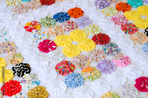 several pieces of Fuxico sewn together forming a bedspread. handmade. artisanal. craft. colorful.