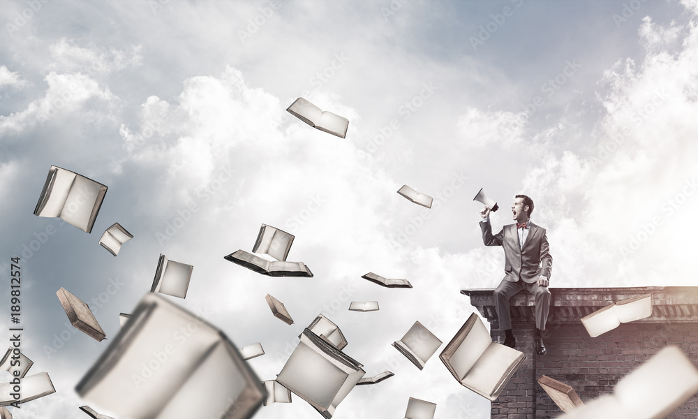 Naklejka premium Businessman on building edge announcing something in loudspeaker