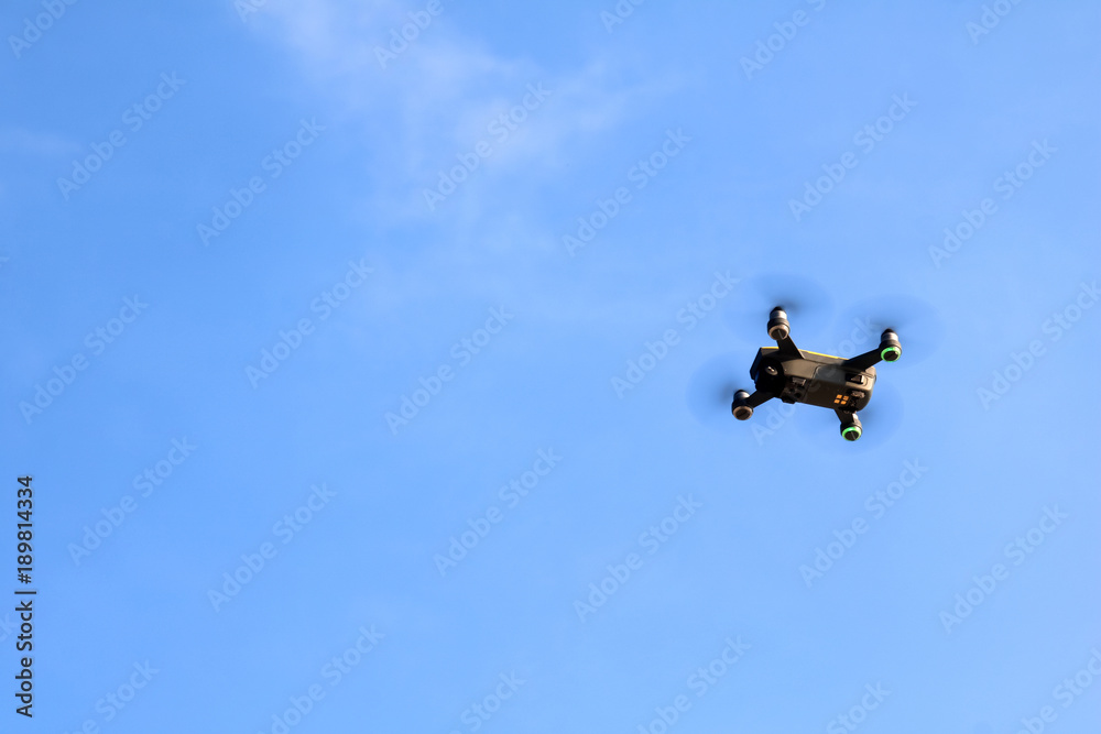 Drone camera or UAV flying in the blue sky Drone camera or UAV flying in the blue sky