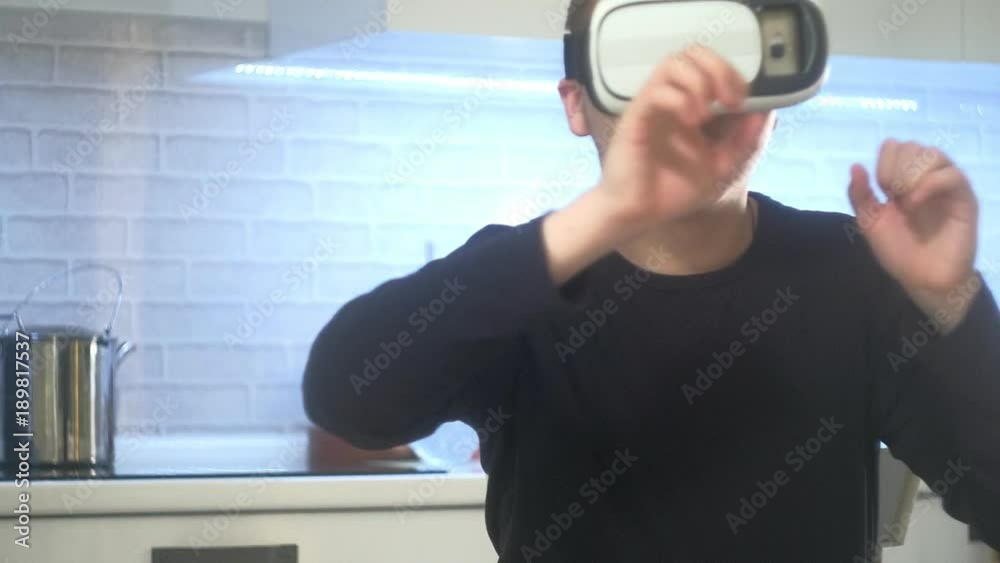 Man Wearing VR Headset at kitchen. Using Gestures with Hands. Man Wearing VR Headset at kitchen. Using Gestures with Hands.