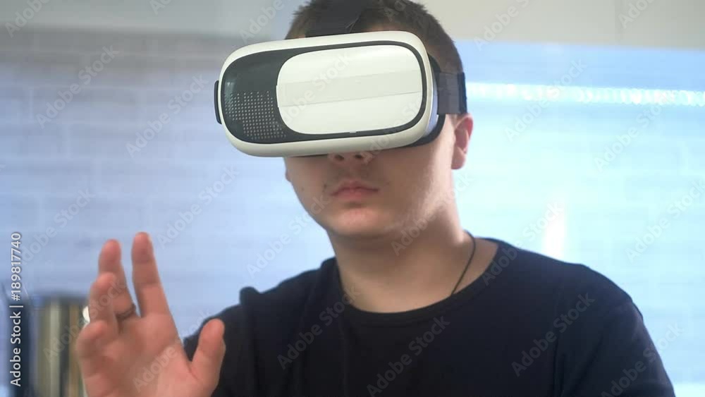 Man Wearing VR Headset at kitchen. Using Gestures with Hands. Man Wearing VR Headset at kitchen. Using Gestures with Hands.