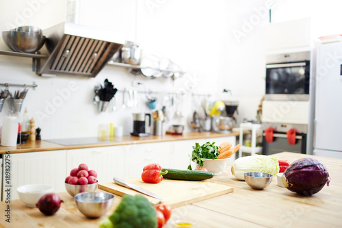 Variety of fresh vegetables on workplace of chef in the kitchen