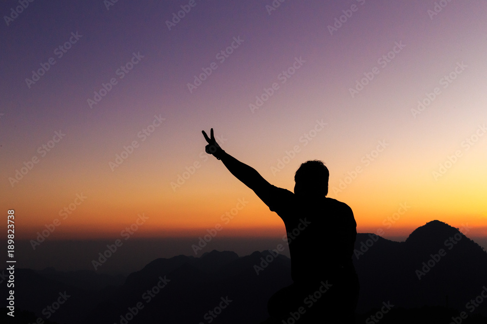 Fototapeta premium Man with arms extended toward heaven at sunrise ,success or prayer concept