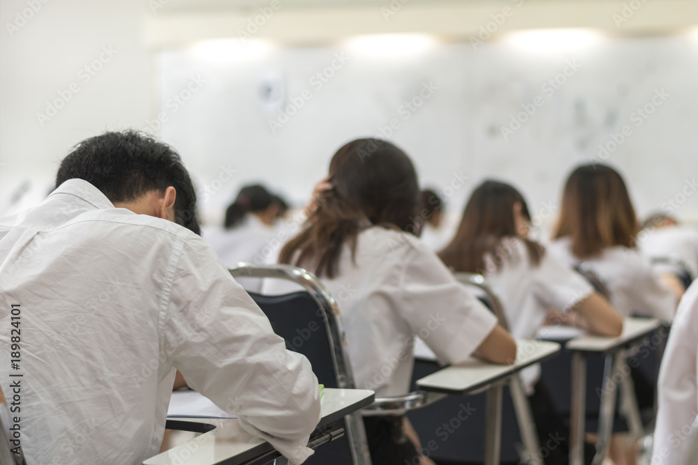 Blur school background university students writing answer doing exam in  classroom Stock Photo | Adobe Stock