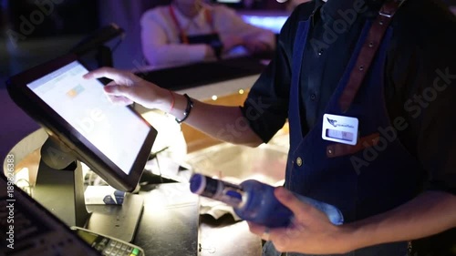 barman in the club makes payment on the terminal