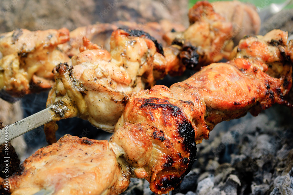 Chicken meat close-up on skewers over charcoal. Chicken meat close-up on skewers over charcoal.