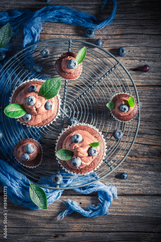 Obraz premium Pyszne muffinki z czekolady, świeżych jagód i śmietany