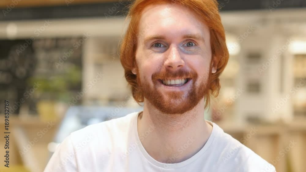 Portrait of Redhead Beard Man Gesturing Victory Sign in Cafe Portrait of Redhead Beard Man Gesturing Victory Sign in Cafe