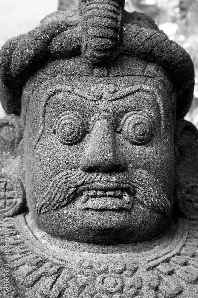 Traditional Balinese stone demon sculpture at Bali, Indonesia.