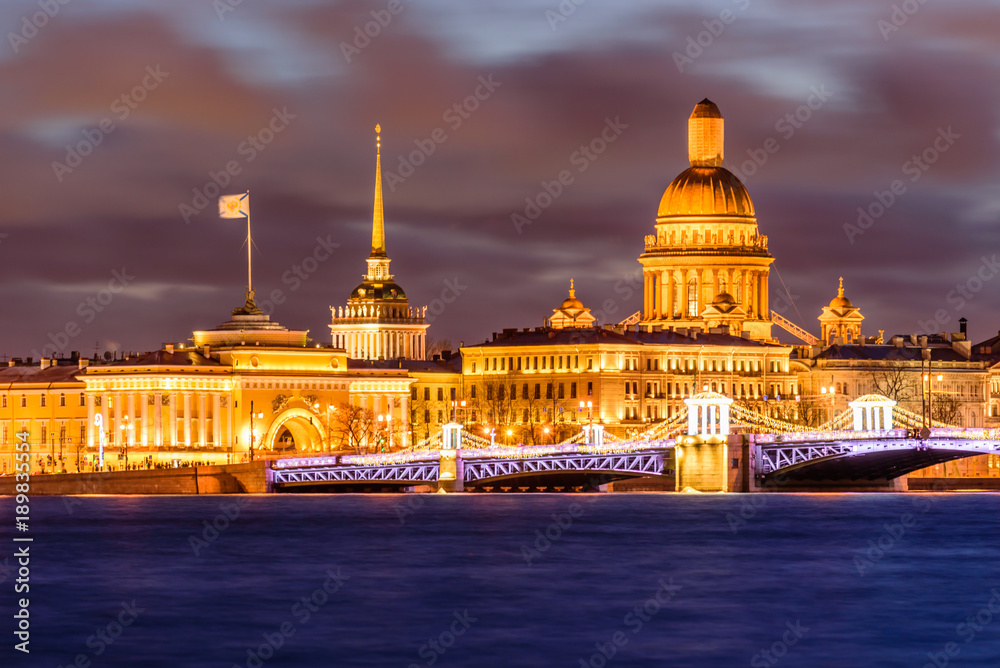 Evening View of the city decorated with lights. View of the main attractions - the Palace Bridge and St. Isaac Cathedral. Russia, Saint-Petersburg.