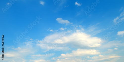 Light cumulus clouds against the blue sky. Wide photo.