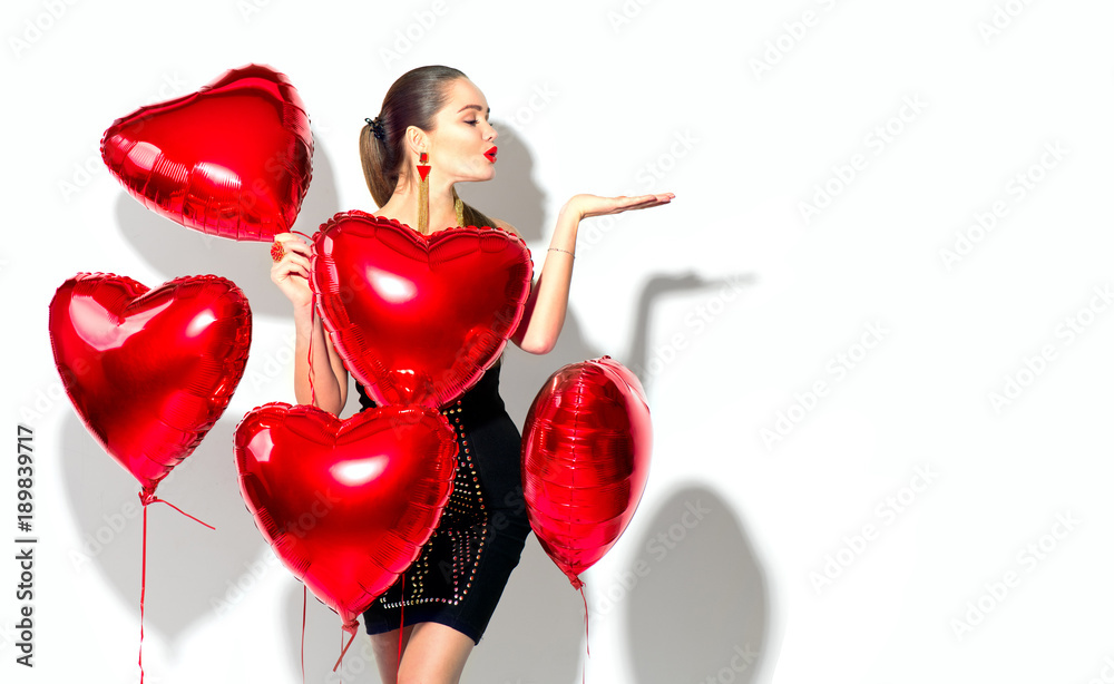 Valentine's Day. Beauty girl with red heart shaped air balloons having fun, isolated on white background - obrazy, fototapety, plakaty 