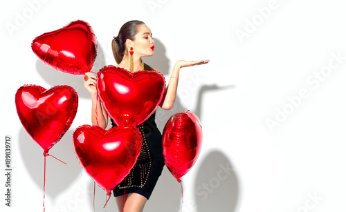 Valentine's Day. Beauty girl with red heart shaped air balloons having fun, isolated on white background