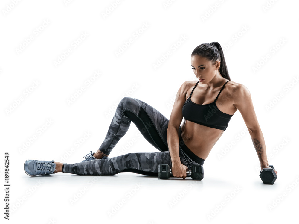 Athletic woman with dumbbells. Photo of sporty woman in sportswear on white background. Strength and motivation Athletic woman with dumbbells. Photo of sporty woman in sportswear on white background. Strength and motivation