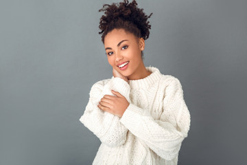 Young african woman isolated on grey wall studio winter concept soft cloth