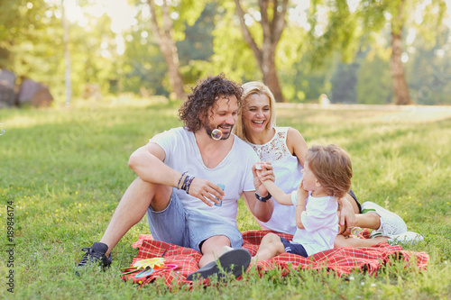 Happy family in the park. Parents with a child play in nature. © Studio Romantic