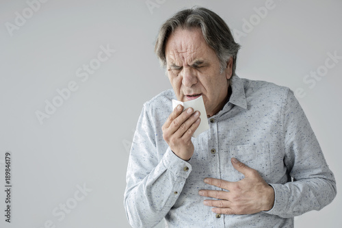 Fototapeta Old man coughing to tissue