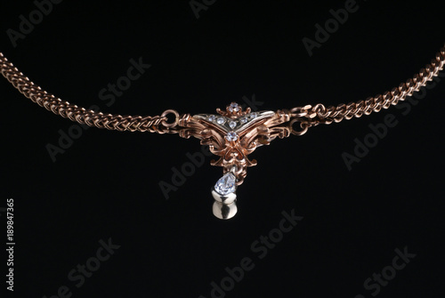 One gold chain with a suspension bracket on a black background