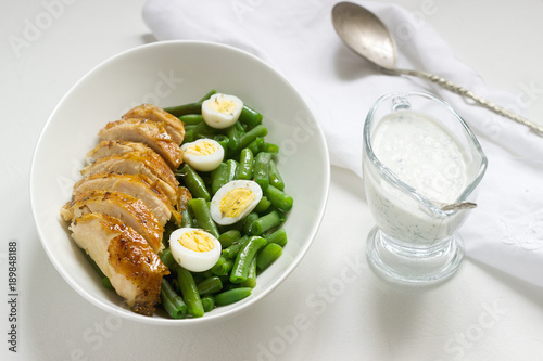 Roasted chicken breasts served with fried egg and boiled green beans.