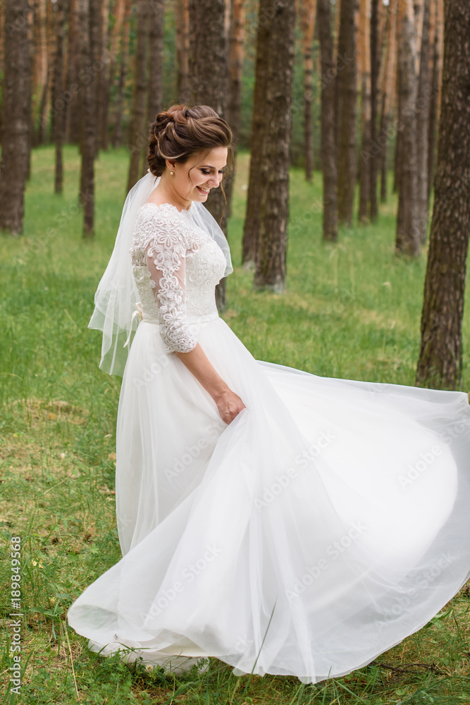 Happy and beautiful bride dance alone in nature