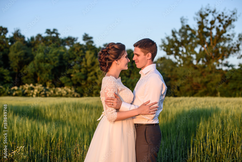 The first kiss of a newly formed family. Beautiful bride and handsome man groom kissing in a forest of pine trees. The first kiss of a newly formed family. Beautiful bride and handsome man groom kissing in a forest of pine trees.