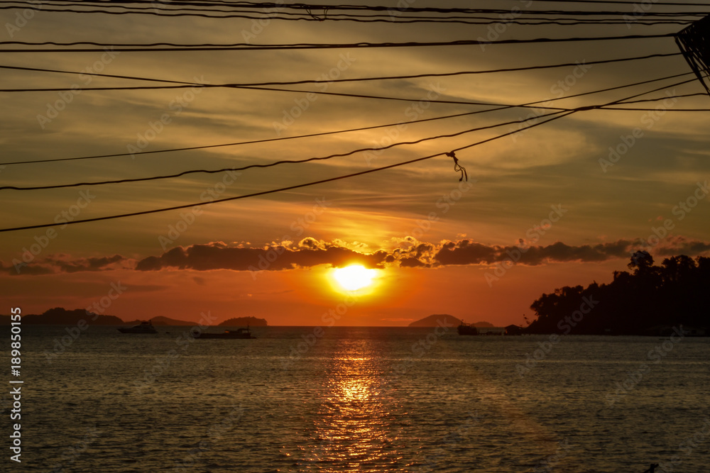 sunrise over tropical island with electric cables