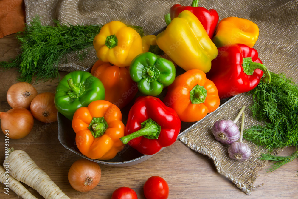 Red, green and yellow sweet bell peppers on table, vegetables on the table. tomatoes, chili peppers