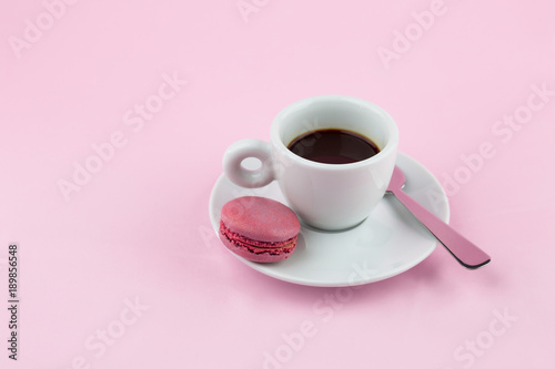 Cappuccino espresso coffee on a pink background with french macaroons or macaron cookies