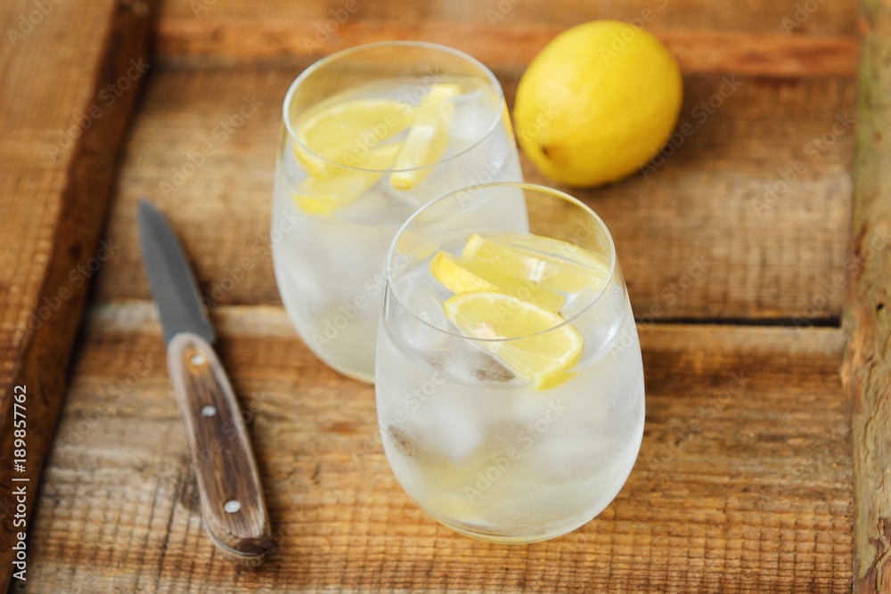 Fresh lemonade with ice and lemon on the table 